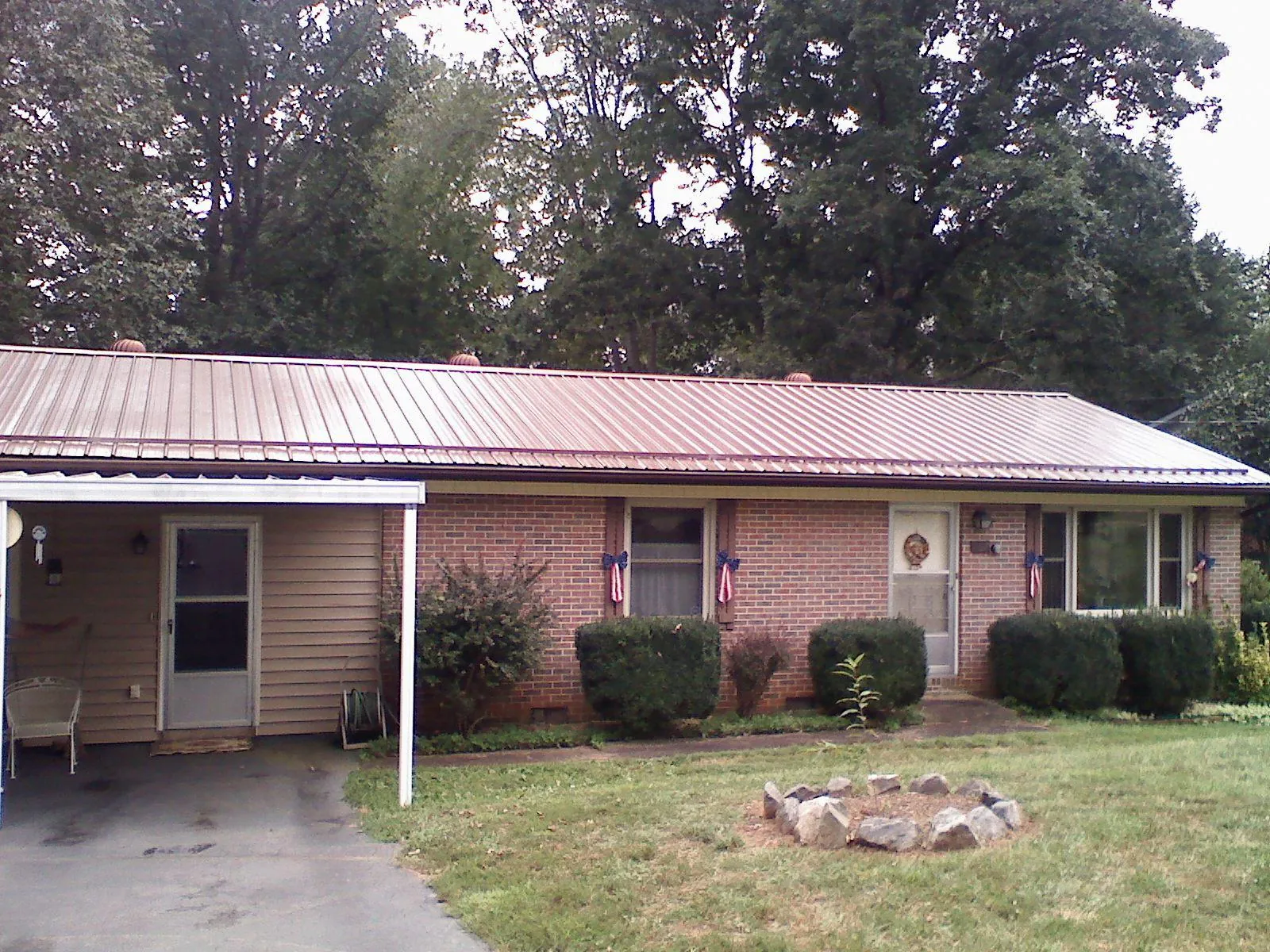 Bronze metal roof and carport on a brick ranch home — Roof Repair work by our crew in Mineral Point
