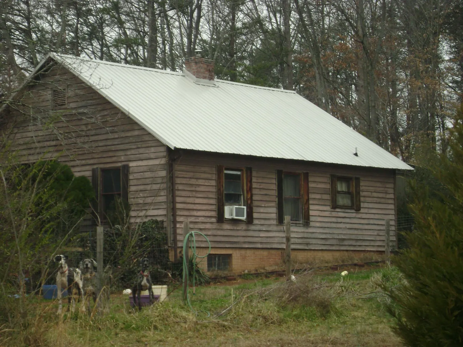 White metal roof on an old wood sided farmhouse, from a Metal Roof Installation job in Mineral Point